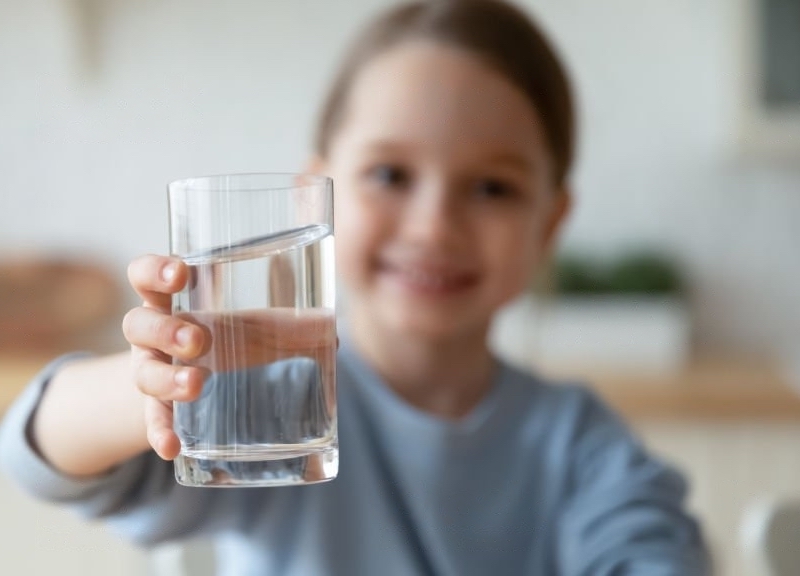 enfant prenant verre d'eau en main